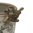 Set of four gold hanging bird decorations perched on planter edge