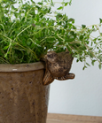 Set of four gold hanging bird decorations perched on planter edge