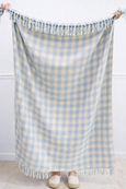 Harbour Check cotton throw in sky blue and natural gingham pattern with soft fringe edge, styled draped and held open indoors