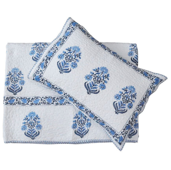 Hand block printed blue and white cotton coverlet set with matching pillow shams, folded and layered