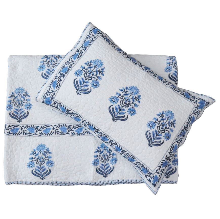 Hand block printed blue and white cotton coverlet set with matching pillow shams, folded and layered