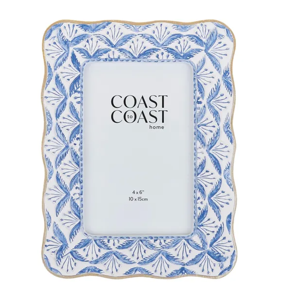 A rectangular photo frame with a rounded, scalloped outer edge. The frame is white with a repeating fan-like pattern in various shades of blue. The inner edge of the frame is a thin, rounded, light-brown colour.