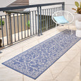 Blue and ivory outdoor runner rug with elegant scroll detailing, styled in a coastal Hamptons-inspired space for indoor or outdoor use.