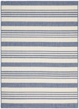 Blue and ivory striped flatweave outdoor rug styled in a coastal setting with rattan furniture, ideal for Hamptons or Malibu-inspired décor.