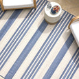 Overhead view of the Malibu Coastal Stripe Outdoor Rug Blue with coastal outdoor furniture and decorative styling.
