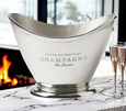 Polished silver oval champagne bucket with scoop front and engraved French motif, ideal for elegant entertaining and wine chilling.
