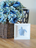 Artificial Blue Ranunculus Hydrangea Bouquet with blue hydrangeas, white ranunculus, and greenery, lifelike coastal-inspired floral arrangement in rattan basket.