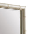 A tall, rectangular mirror with a wide, decorative frame. The frame is finished in a soft off-white and features a raised, textured pattern that resembles bamboo or rattan rods running vertically. Corner detail.