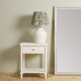 A tall, rectangular mirror with a wide, decorative frame. The frame is finished in a soft off-white and features a raised, textured pattern that resembles bamboo or rattan rods running vertically.