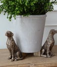 Gold Labrador pot stand figures supporting a planter on wooden surface