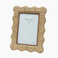 Angled view of the Rattan Wavy Photo Frame 4x6 showcasing its woven texture and decorative scalloped border.