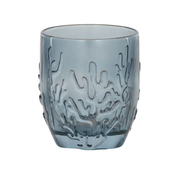 Blue glass tumbler with embossed coral reef pattern styled for a coastal Hamptons-style table