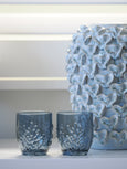 Reef Embossed Tumbler Blue featuring textured coral-inspired detailing, styled in a pair beside a sculptural blue ceramic vase in a coastal Hamptons interior.