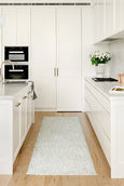 Rogue Mist runner rug styled in a bright white coastal kitchen with timber flooring