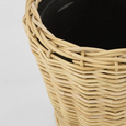 Set of two natural round rattan baskets with black inner pots for indoor plants.