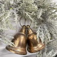 Rustic twin metal bells with rope hanger in warm antiqued copper tone.