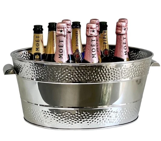 Polished stainless steel oval champagne bucket with dotted double-border design, filled with champagne bottles, perfect for entertaining.