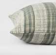 Close-up of sage striped cushion showing raised weave texture and coastal detailing