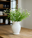 Scilla Rope Vase in off-white stoneware with scalloped rim styled with fresh flowers on a wooden table
