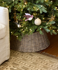 large washed grey wicker tree skirt placed under Christmas tree for rustic festive styling
