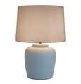 Somerset Ceramic Table Lamp in duck egg blue with white shade, styled on a wooden console in a Hamptons-inspired living space with bulb on.