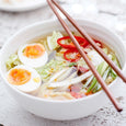 Sophie Conran white noodle bowl filled with ramen and chopsticks on a light tabletop