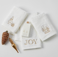 Set of three white cotton Christmas hand towels with champagne-gold embroidered motifs including presents, snow globe, and ‘JOY’ design.