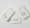 Set of three white cotton Christmas hand towels with champagne-gold embroidered motifs including presents, snow globe, and ‘JOY’ design.