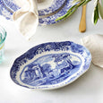 Spode Blue Italian oval serving dish styled on a table with linen napkin and gold cutlery