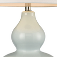 Light blue ceramic table lamp with white shade on white background