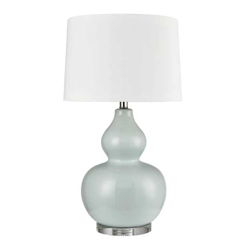 Light blue ceramic table lamp with white shade on white background