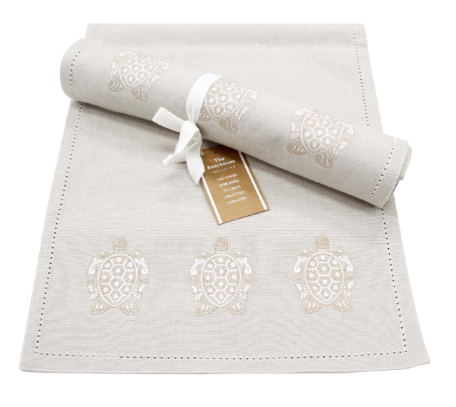 Stonewashed chambray cotton table runner with embroidered turtle design in neutral coastal tones