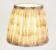 Small pleated lamp shade with terracotta floral pattern illuminated