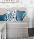 Blue velvet and floral Hamptons cushions styled together on a neutral sofa