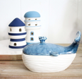 A sleek, white ceramic trinket box shaped like a whale, with a separate lid for small storage. The design is simple and elegant, suitable for Hamptons or coastal-themed home decor.