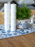 White bamboo salt and pepper grinder styled on blue floral table runner