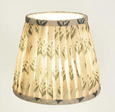 Blue patterned pleated lamp shade illuminated with warm light
