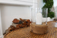 Small Amalfi hurricane lamp creating warm ambient lighting on a bedside table

