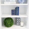 Artificial Boxwood Ball styled on a white bookcase with blue and white ceramics, books and candles in a Hamptons home.