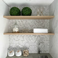 floating timber shelves in a Hamptons-inspired laundry with decorative accessories.