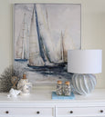 Arya lamp styled on white console with coastal artwork and decor