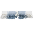 Folded Atlanta Chambray Blue table runner showing woven blue and white cotton design and two-tone tassel fringe.