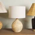 Natural woven rattan table lamp adding warmth and texture to a contemporary living room.
