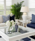 white ceramic lamp styled in coastal living room with blue cushions and white furniture