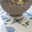 hydrangea butterfly table runner styled with wicker fruit basket, coastal table setting with soft blue and green tones