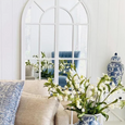 Bayside Slate Blue Hamptons Armchair reflected in an arched mirror within a blue and white coastal living room.