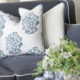 Bellamy Garden Cushion Coastal Blue 50cm layered with white cushions on a blue sofa in a classic Hamptons living room.
