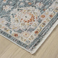 Corner of Bellamy Sea Glass Rug showing the detailed floral border, textured pile and genuine short fringe.