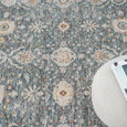 Bellamy Sea Glass Rug close-up showing intricate ivory florals and muted rust and olive accents on a blue-green ground.