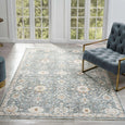 Bellamy Sea Glass Rug styled in a light living room with blue upholstered armchair and timber flooring.